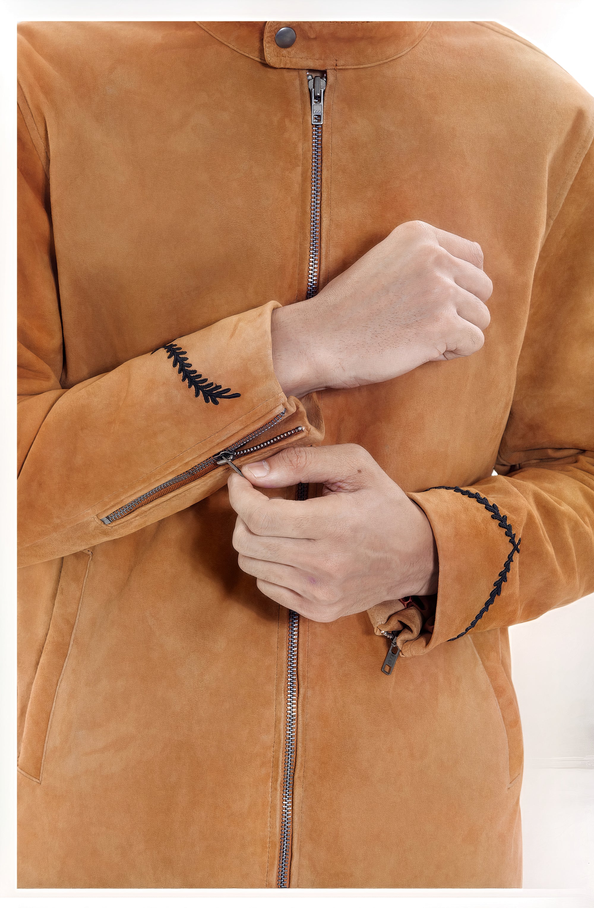 Male model detail close-up front shot, wearing our new Achilles style, a Tan suede/nubuck racer jacket, zipped all the way up, showcasing embroidery detail and front body zip closure.