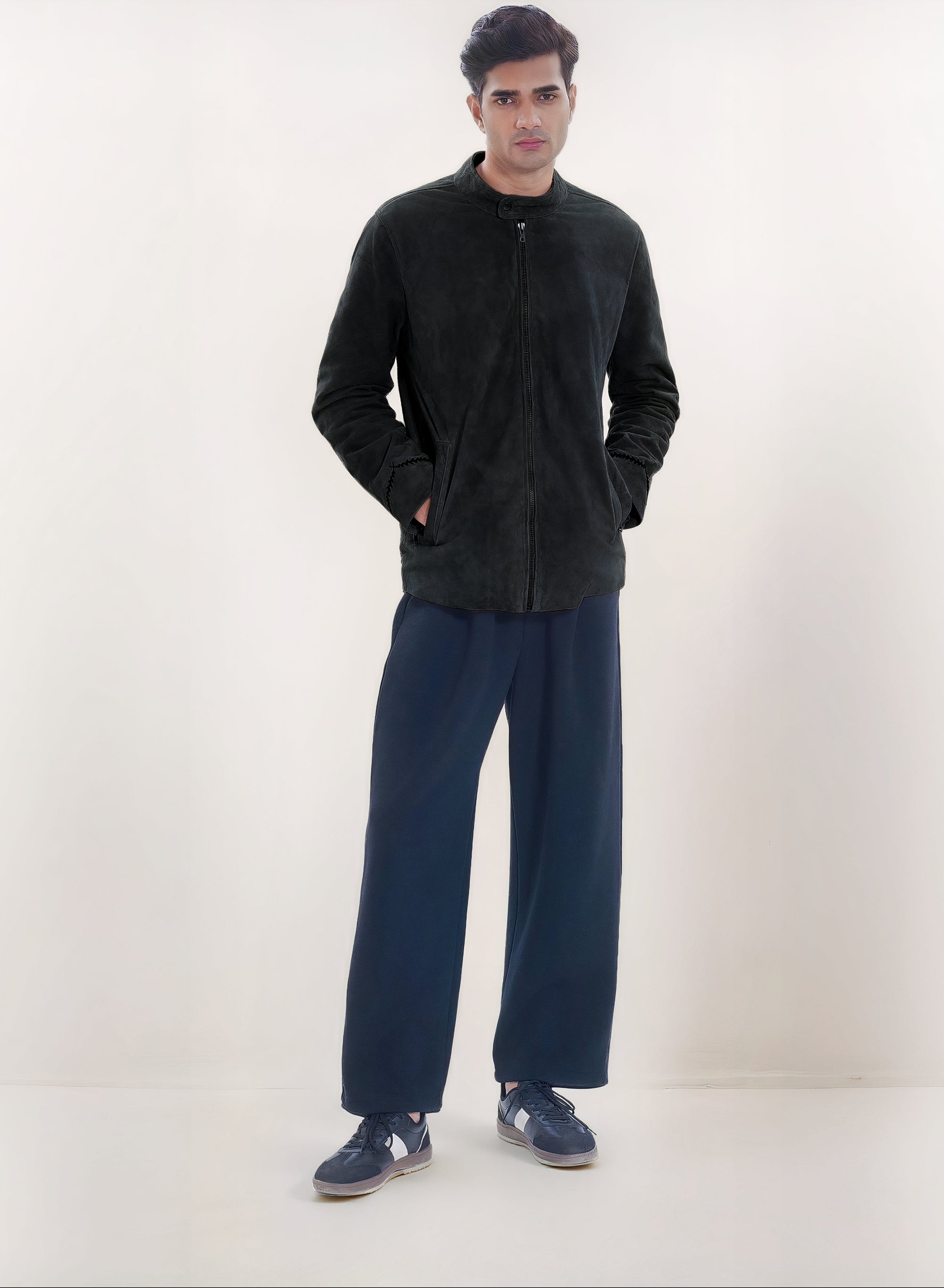 Male model full front shot, wearing our new Achilles style, a Black suede/nubuck racer jacket, fully zipped up, showcasing embroidery detail, and dark pants on a white background.