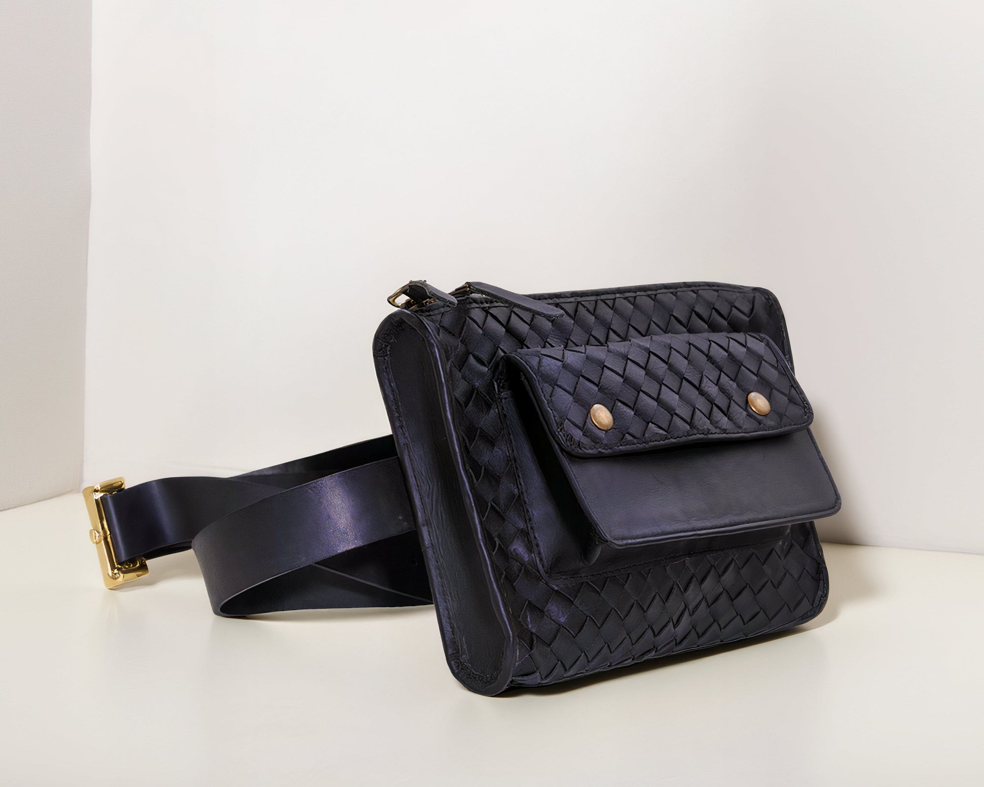 Front shot of our Apollo Loculus black woven belt bag on a white surface with a light gray background