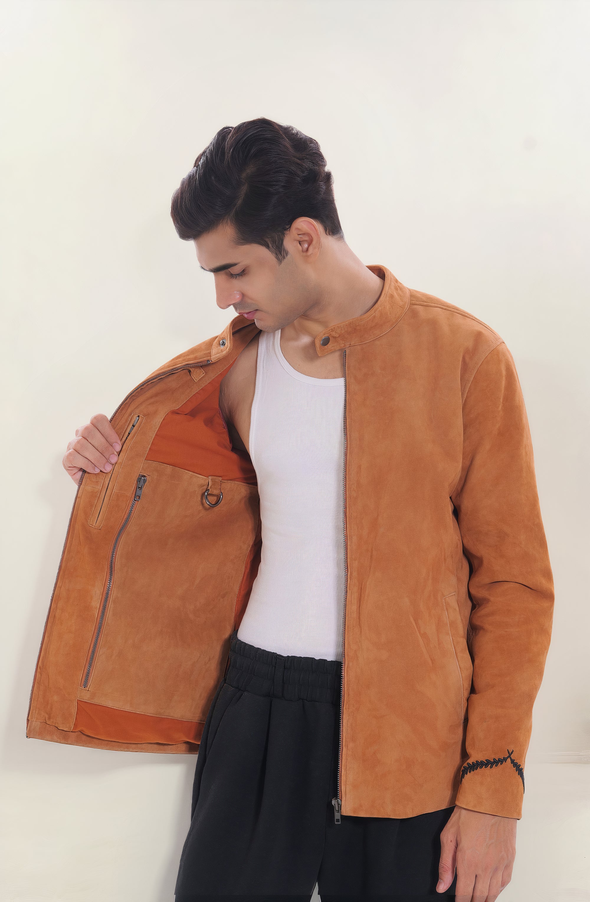 Male model half front shot, wearing our new Achilles style, a Tan suede/nubuck racer jacket showcasing the 2 right side inner pockets along with a hanging loop and a D-ring.