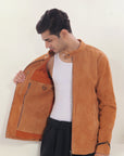 Male model half front shot, wearing our new Achilles style, a Tan suede/nubuck racer jacket showcasing the 2 right side inner pockets along with a hanging loop and a D-ring.