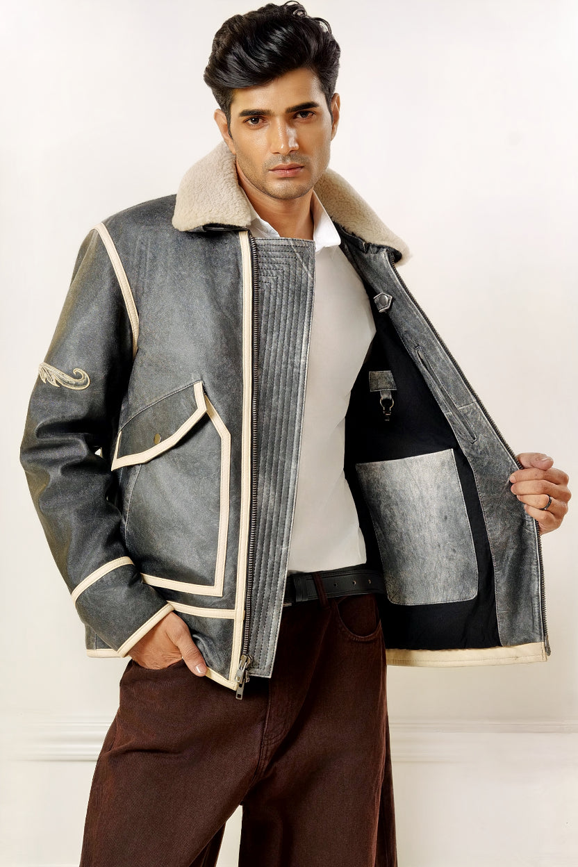 Male model half front shot, wearing our new Icarus style, a vintage-looking weathering grey colour flight jacket showcasing the 2 left side inner pockets along with a hanging loop and a glove hanging clip.