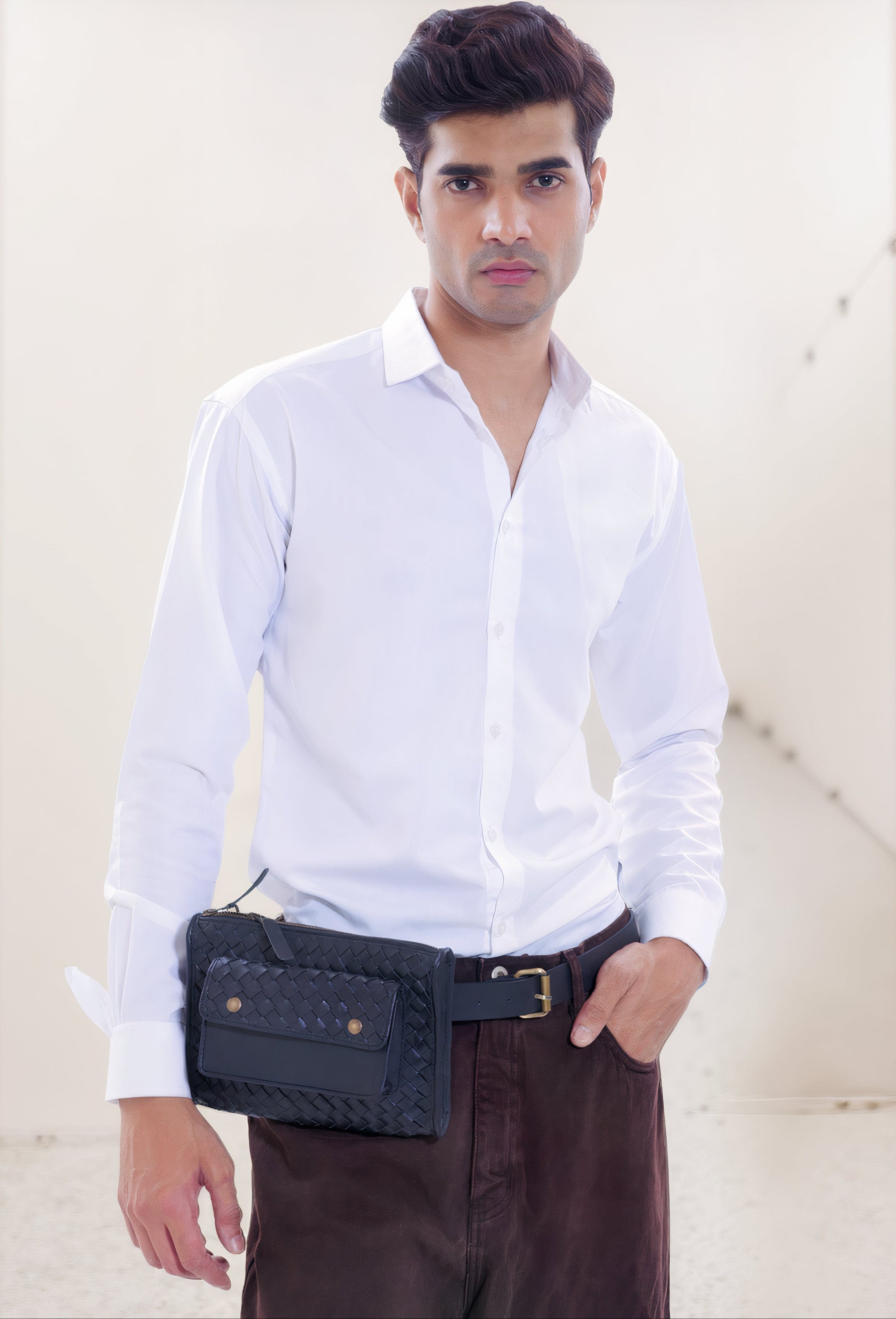 Model shot of our Apollo Loculus black woven belt bag, featuring our male model wearing a white dress shirt and dark dress pants, with the belt bag at his waist. 
